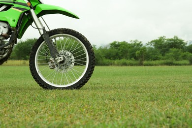 Photo of Stylish green cross motorcycle outdoors, space for text