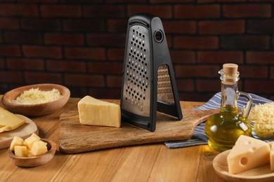 Different types of cheese and grater on wooden table