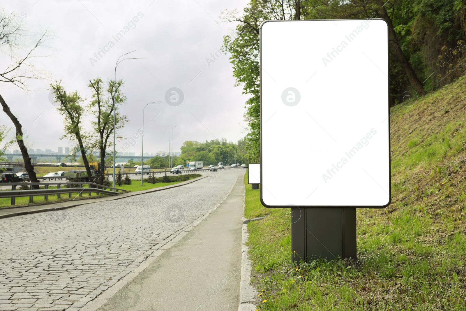 Photo of Blank advertising board on city street. Mockup for design