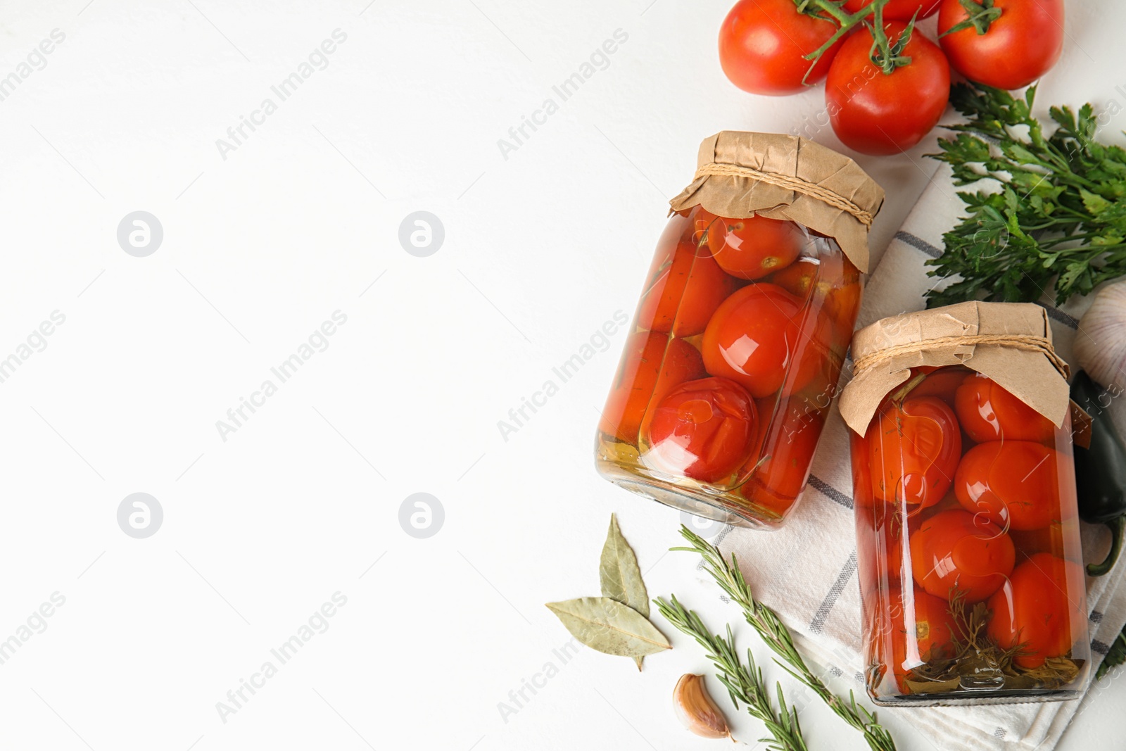 Photo of Flat lay composition with pickled tomatoes in glass jars on white table