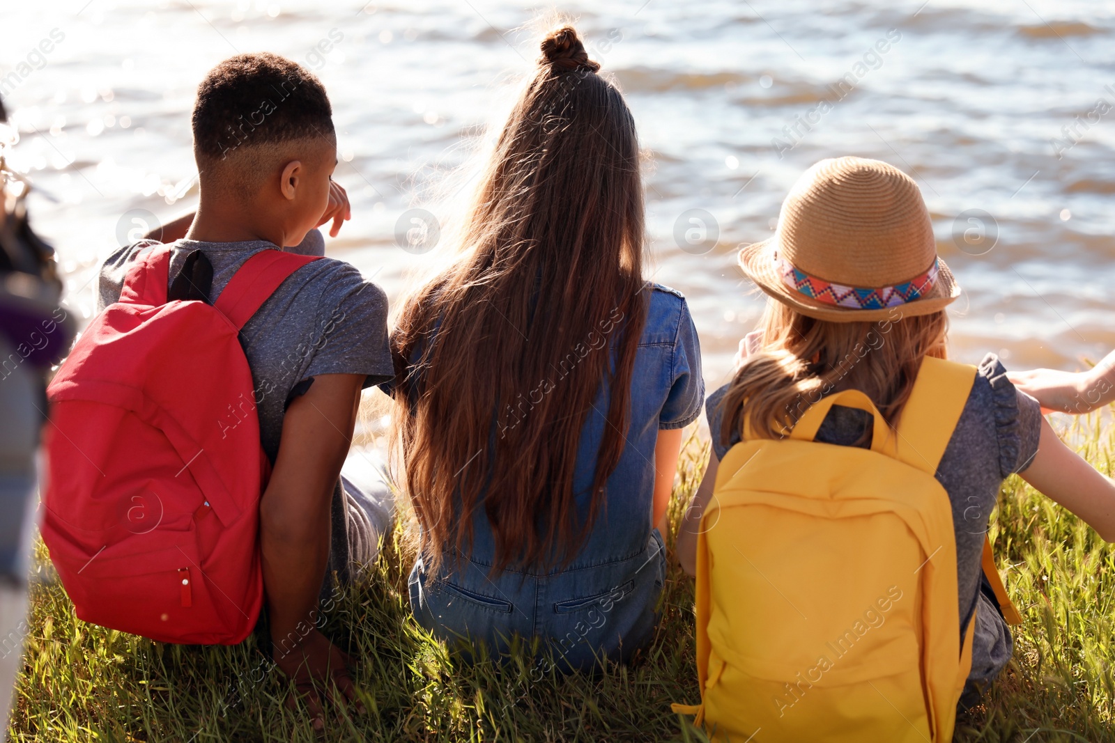 Photo of Group of children with backpacks on coast. Summer camp