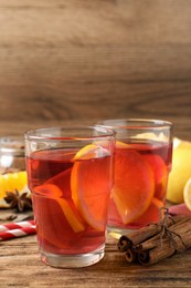 Photo of Aromatic punch drink and ingredients on wooden table