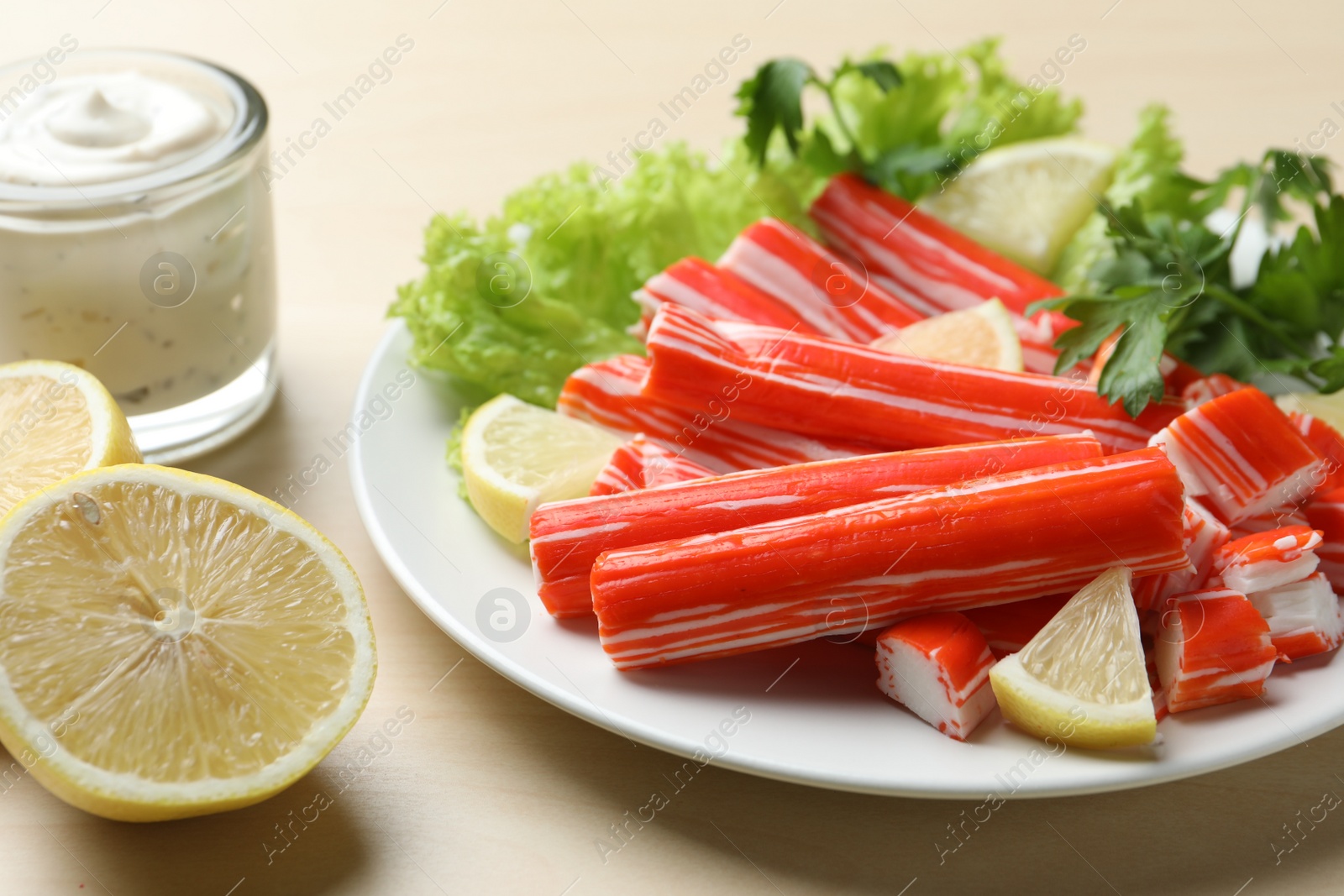 Photo of Delicious crab sticks served on wooden table, closeup