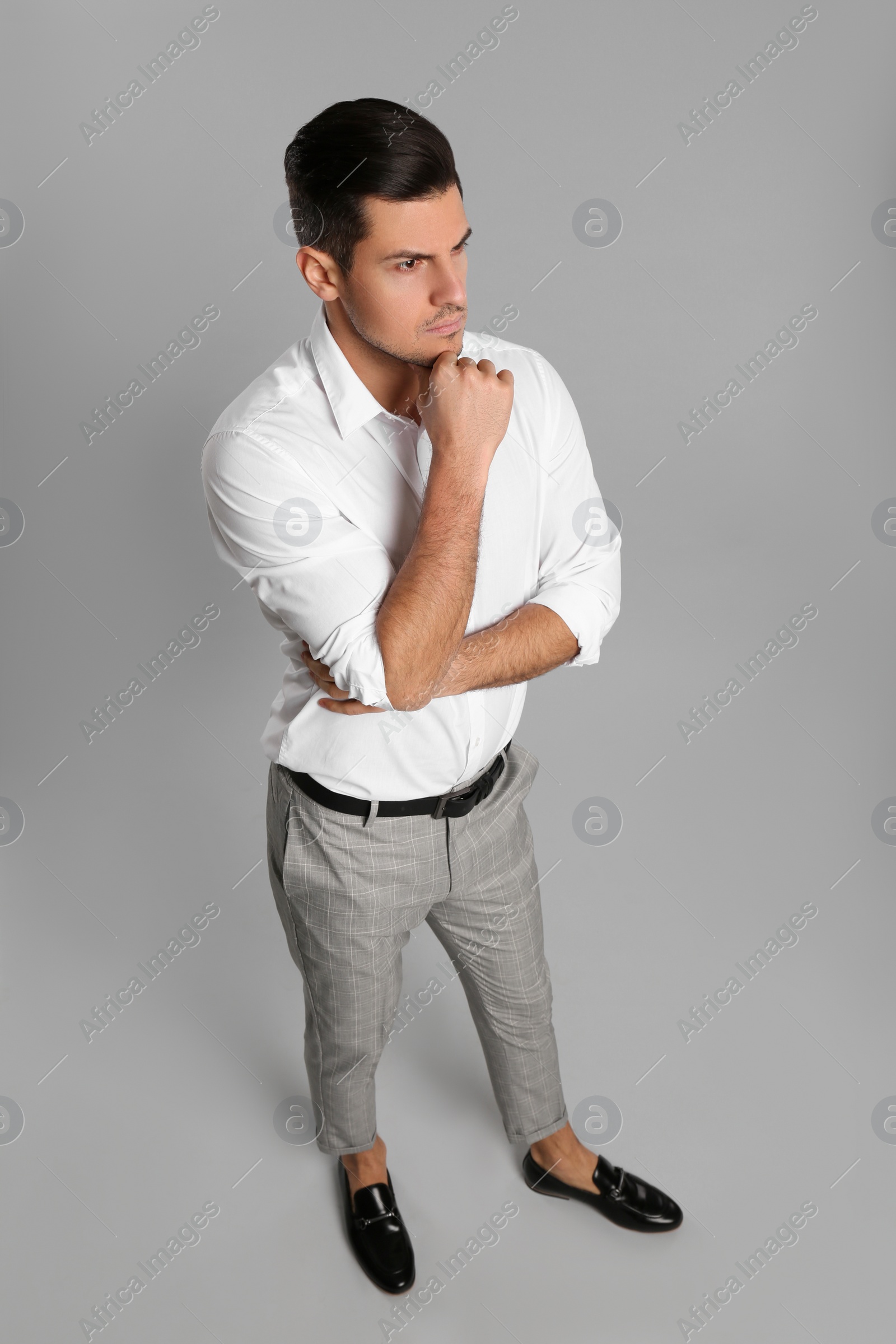 Photo of Thoughtful businessman in formal clothes on grey background