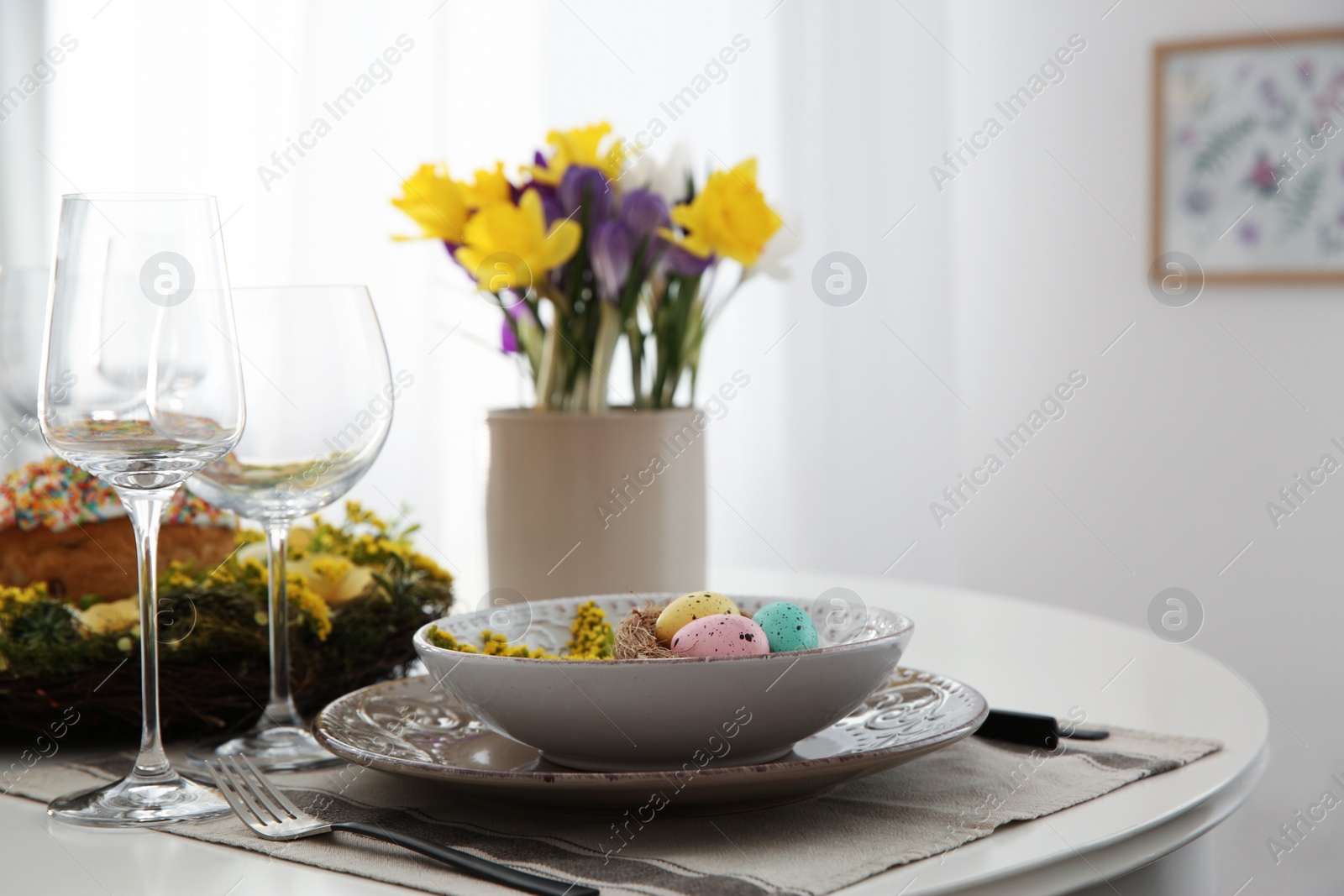 Photo of Festive Easter table setting with beautiful flowers and eggs indoors