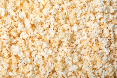 Photo of Fresh tasty popcorn as background, top view