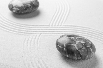 Photo of Stones on sand with pattern. Zen concept