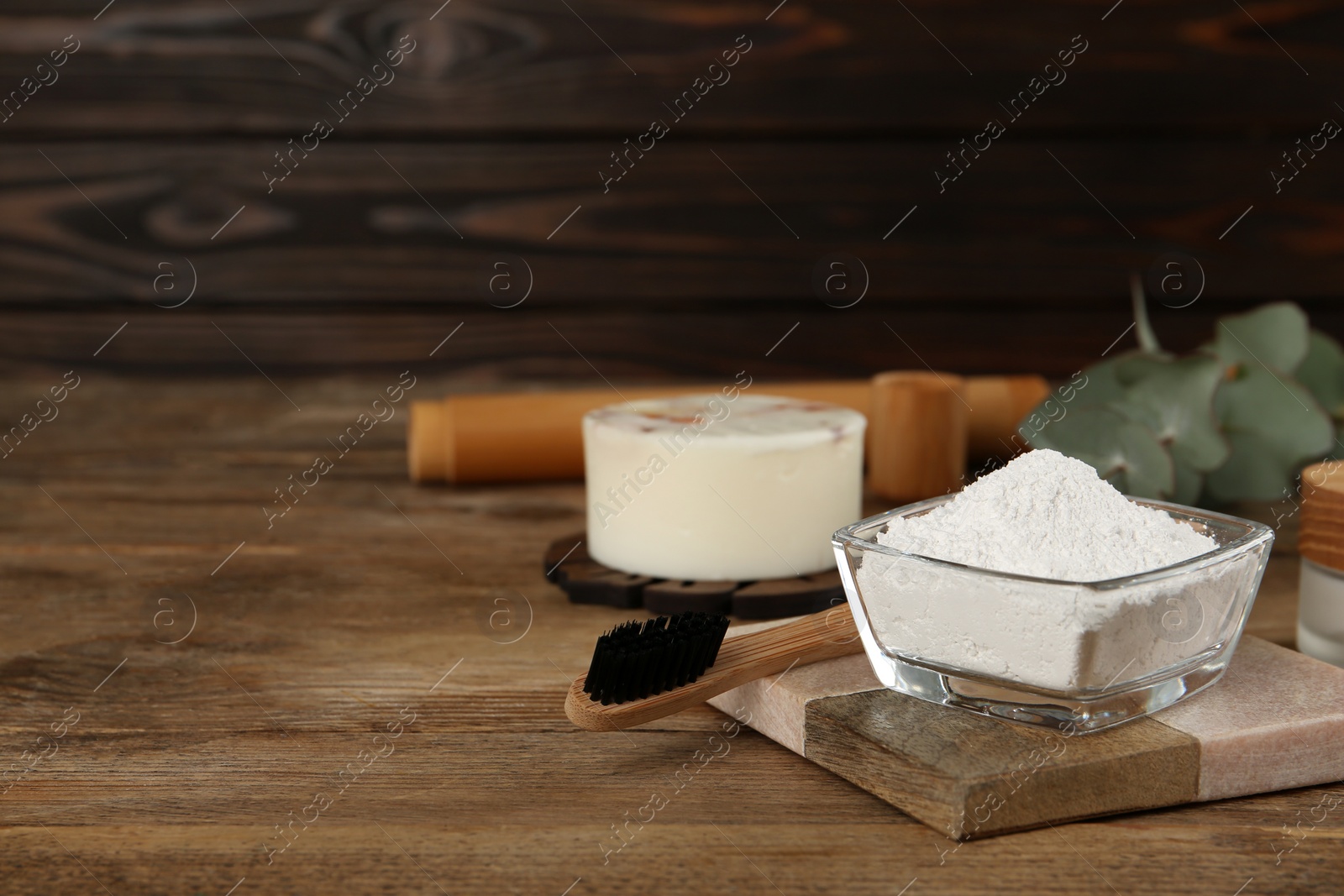 Photo of Tooth powder and brush on wooden table, space for text