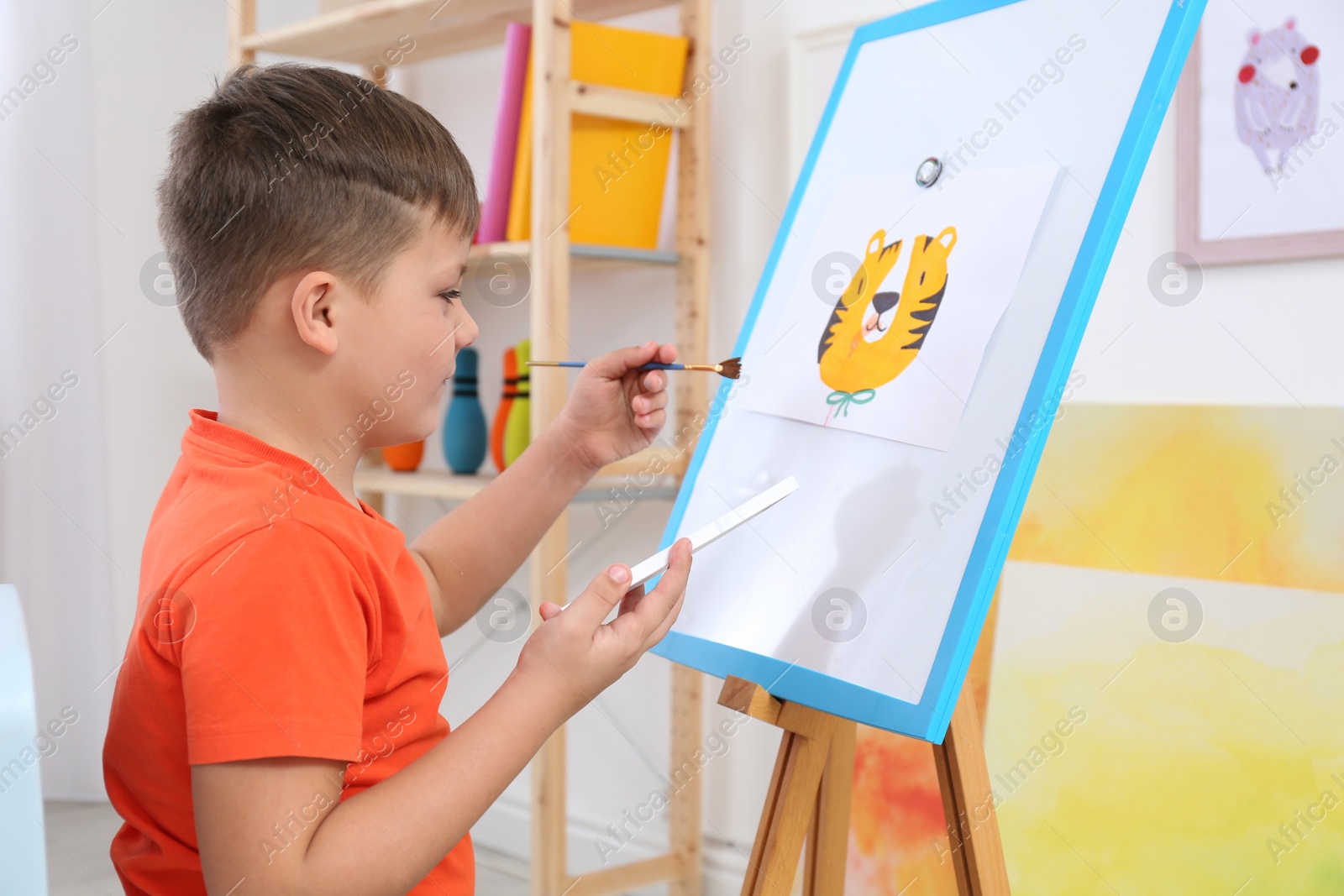 Photo of Cute little child painting during lesson in room