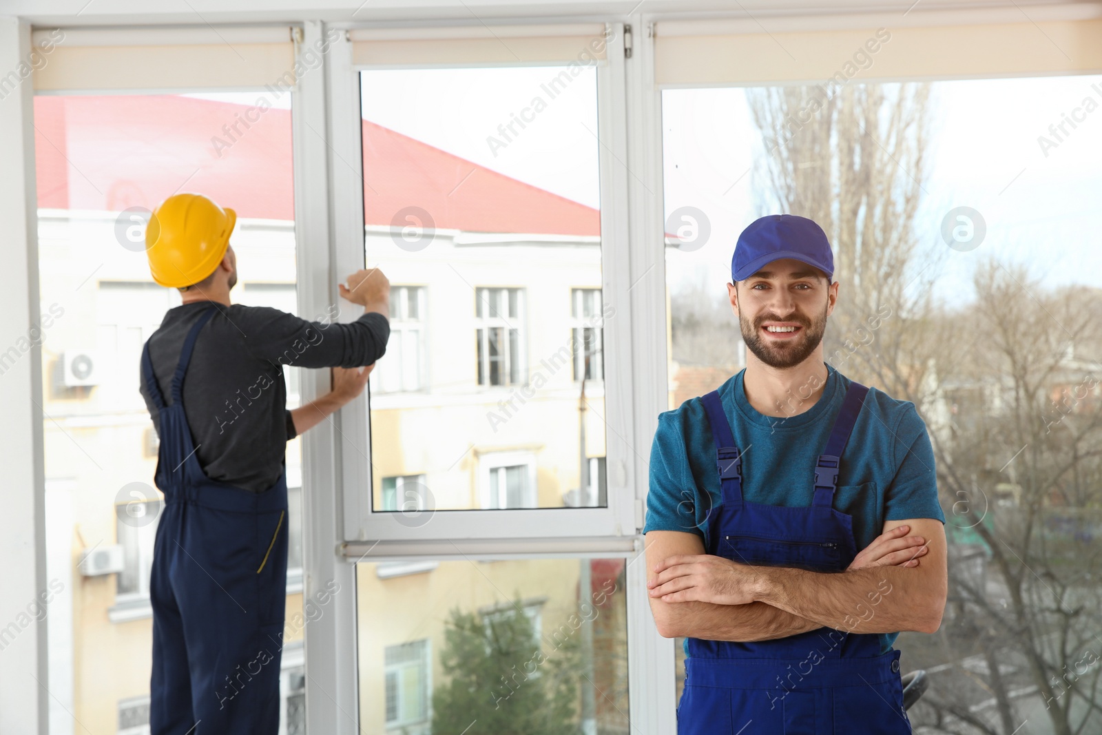 Photo of Construction workers installing plastic window in house