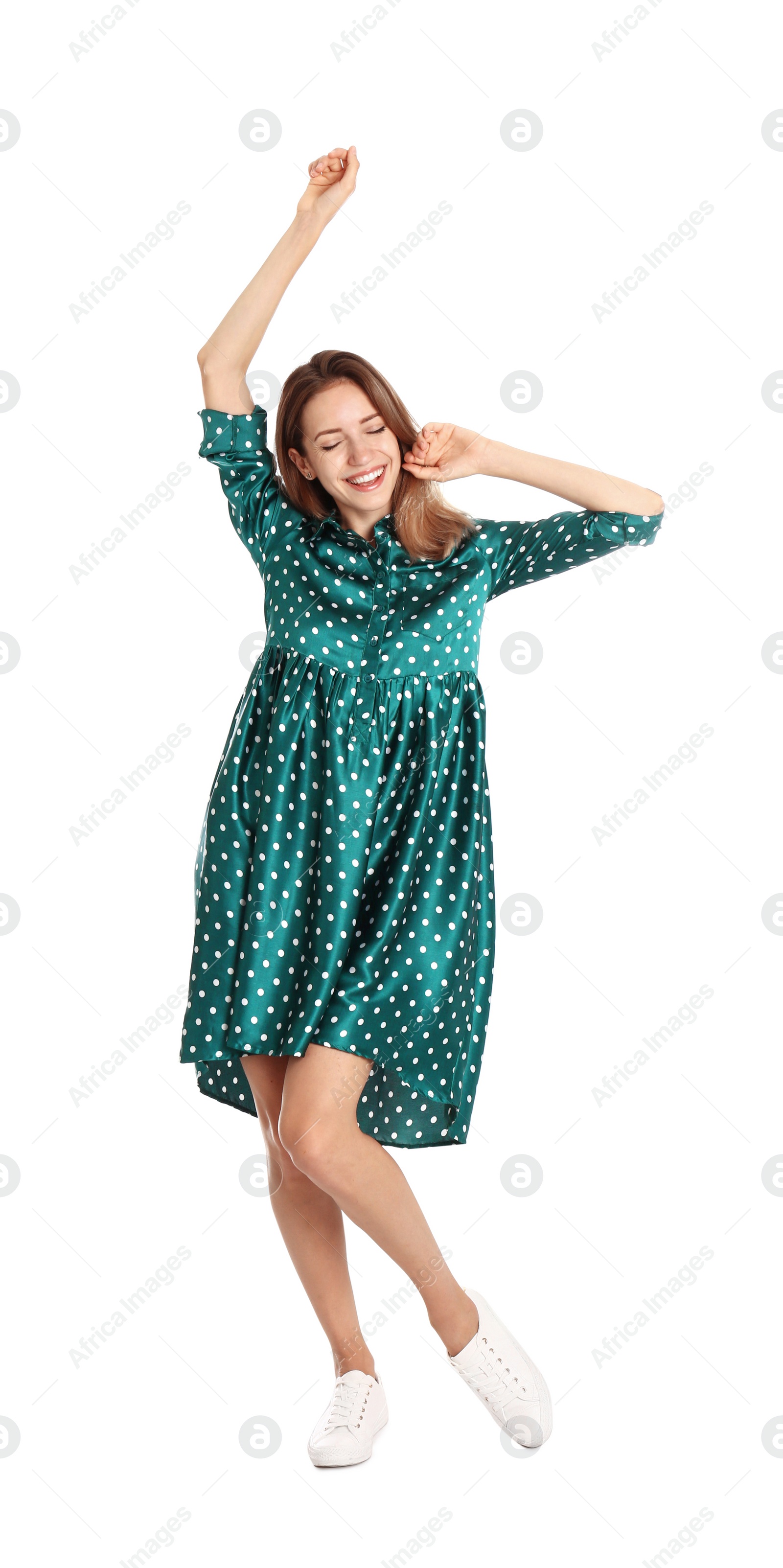 Photo of Beautiful young woman in green dress dancing on white background