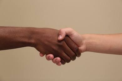 Photo of Men shaking hands on beige background, closeup