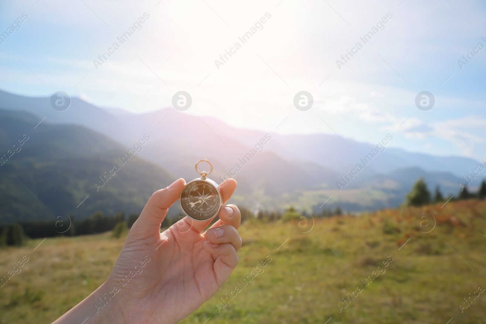 Photo of Woman using compass during journey in mountains, closeup