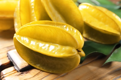 Photo of Delicious fresh carambola fruits on wooden table, closeup