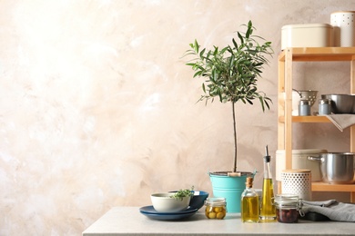 Fresh olive oil and kitchen utensils on table