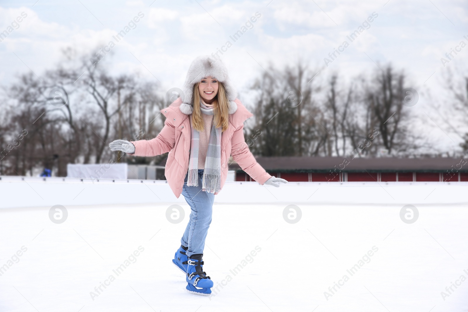 Image of Happy woman skating along ice rink outdoors