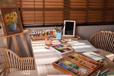 Photo of Artist's workplace with soft pastels and tablet on table