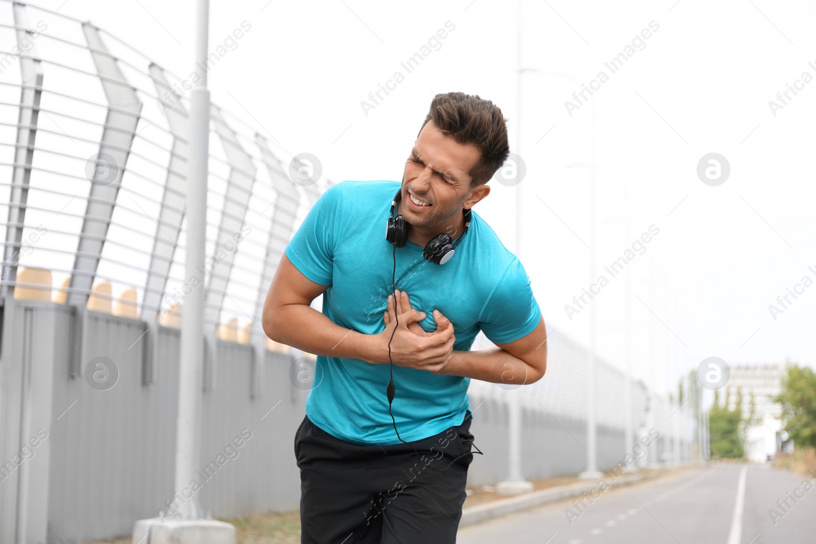 Photo of Young man having heart attack while running outdoors