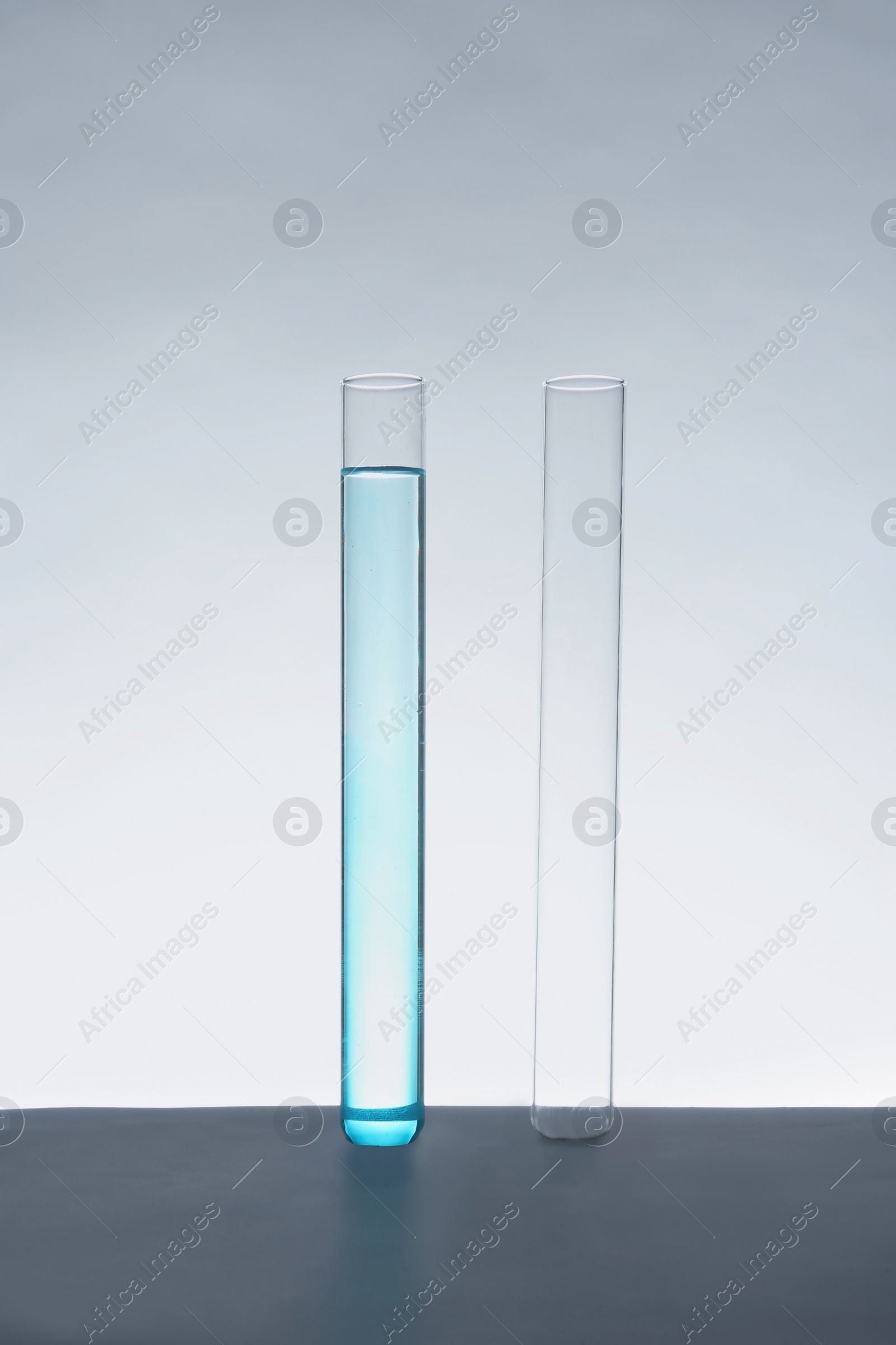 Photo of Empty and filled test tubes on table against white background. Laboratory analysis