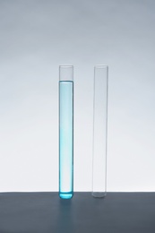 Photo of Empty and filled test tubes on table against white background. Laboratory analysis