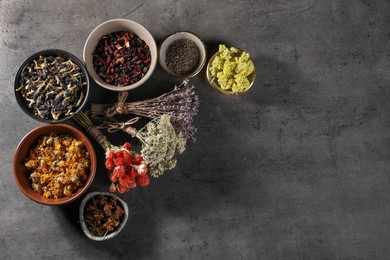 Photo of Many different dry herbs and flowers on dark grey table, flat lay. Space for text