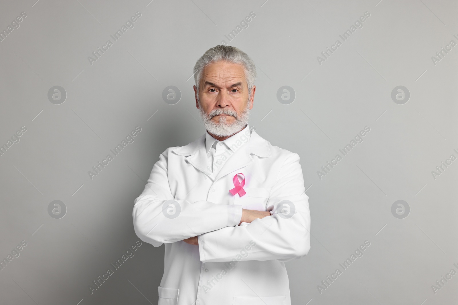 Photo of Mammologist with pink ribbon on gray background. Breast cancer awareness