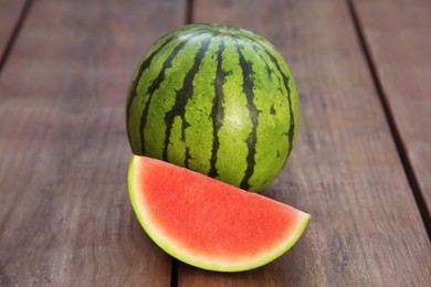 Whole and cut delicious ripe watermelons on wooden table