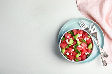 Photo of Delicious salad with watermelon, cucumber and cheese on white table, flat lay. Space for text