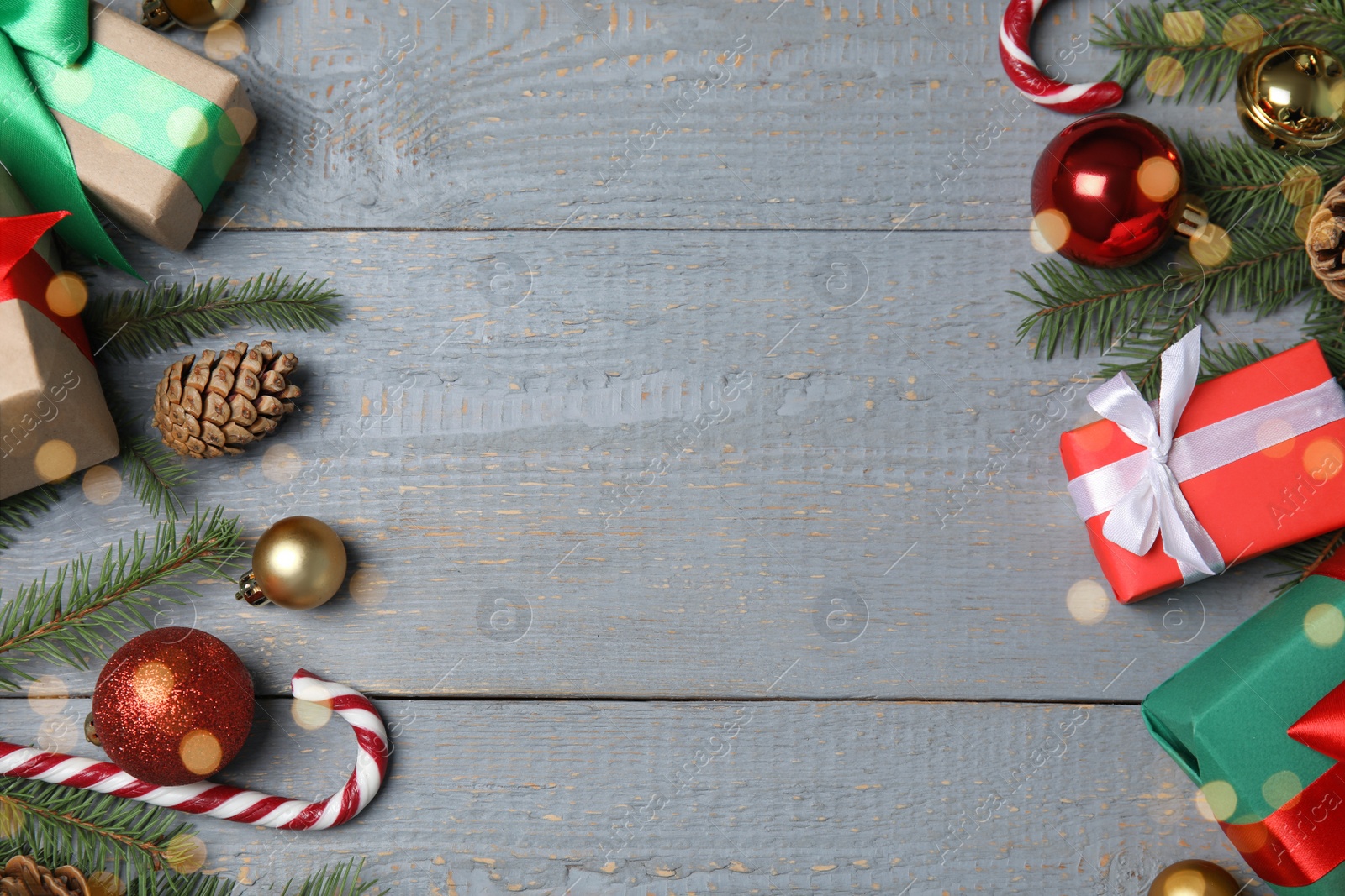 Photo of Christmas greeting card with space for text. Flat lay composition of fir tree branches and festive decor on wooden background