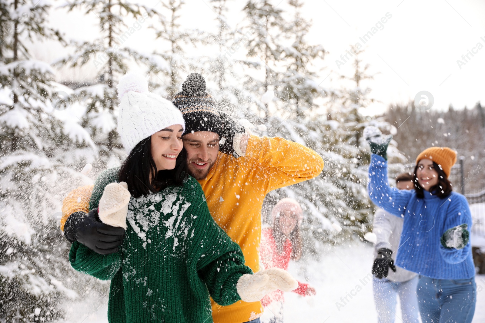 Photo of Group of friends playing snowballs outdoors. Winter vacation