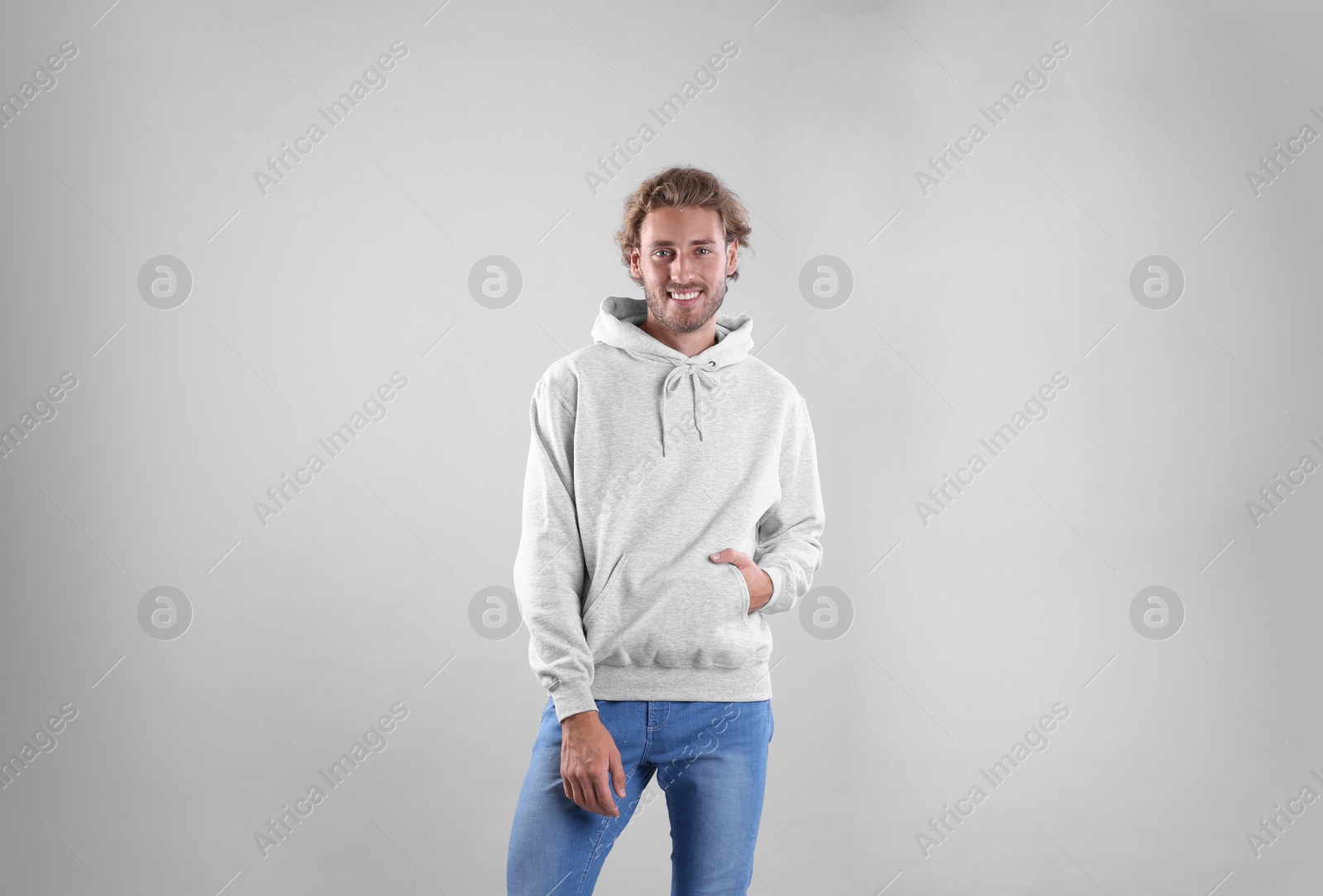 Photo of Portrait of man in hoodie sweater on light background. Space for design