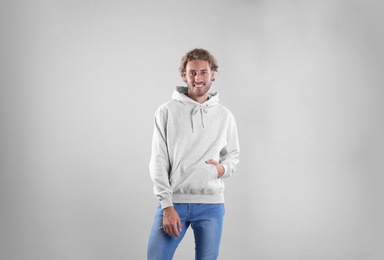 Photo of Portrait of man in hoodie sweater on light background. Space for design