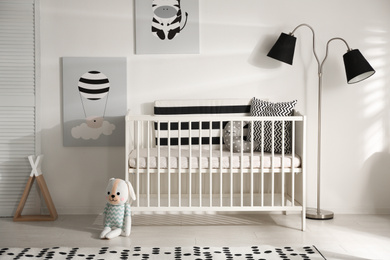 Photo of Cute baby room interior with crib and decor elements