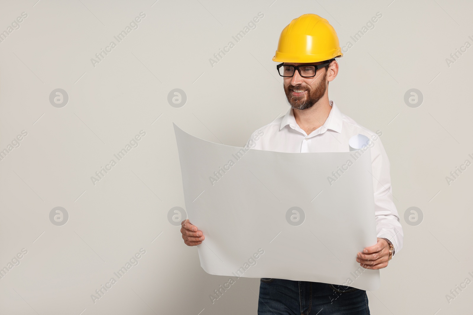 Photo of Professional engineer in hard hat with draft on white background, space for text