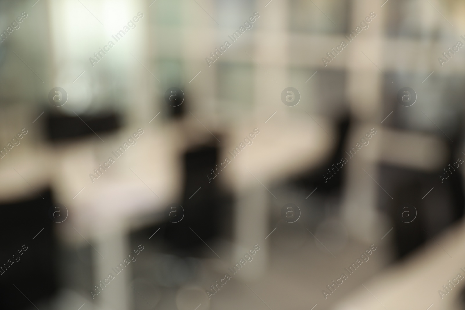 Photo of Blurred view of cozy workspaces with tables and chairs in office