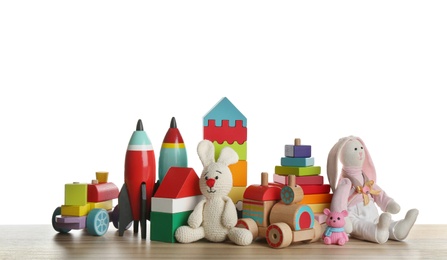 Set of different toys on wooden table against white background