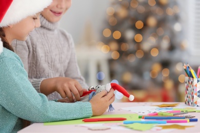 Little children making toy at table indoors, closeup. Christmas season