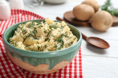 Photo of Bowl with tasty mashed potatoes on table