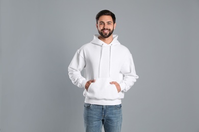 Portrait of young man in sweater on grey background. Mock up for design