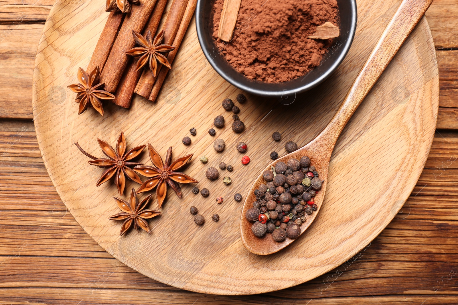 Photo of Aromatic anise stars and spices on wooden table, flat lay