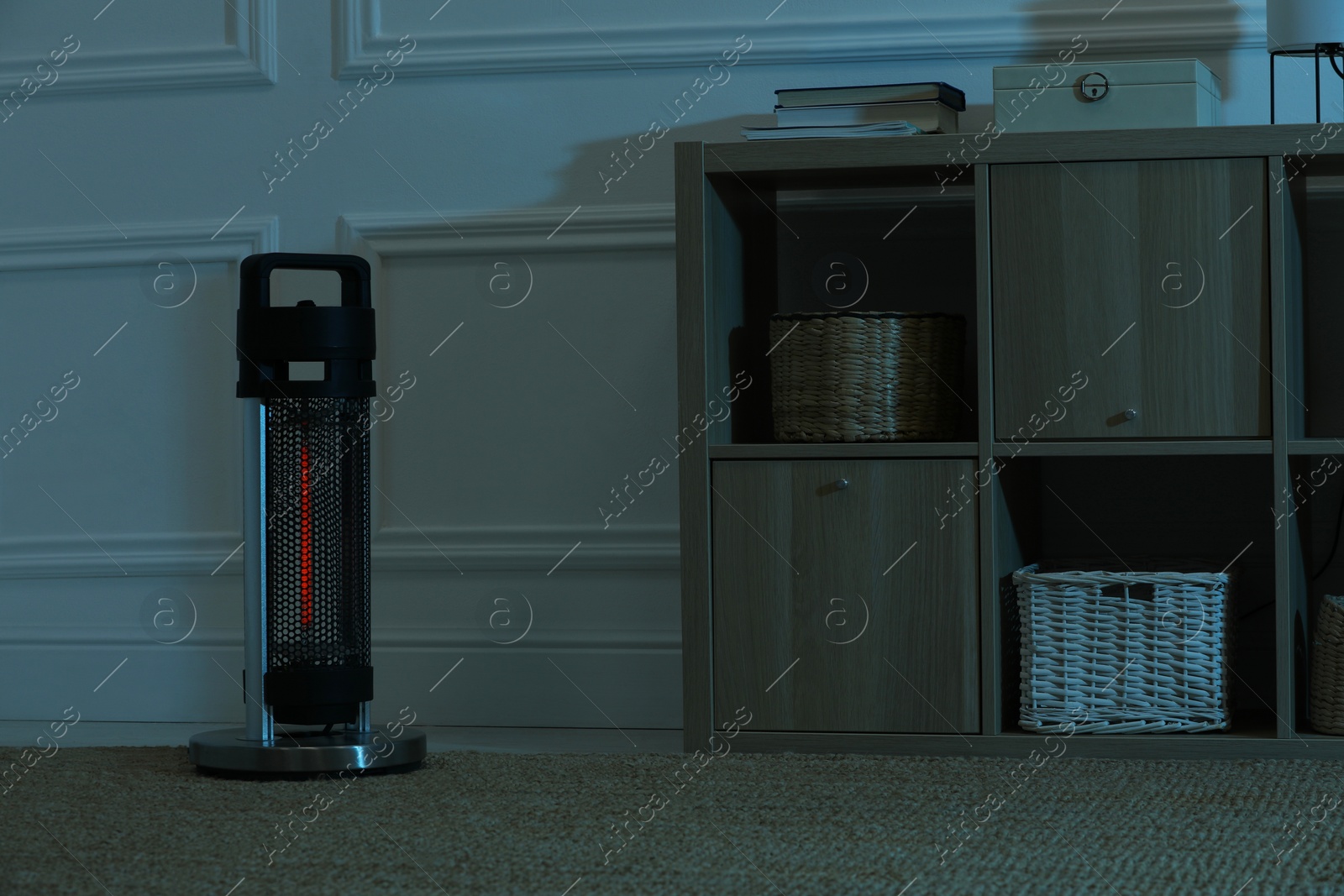 Photo of Electric infrared heater in dark room at night