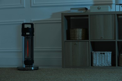 Electric infrared heater in dark room at night
