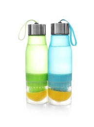 Photo of Sport bottles with lemon water on white background