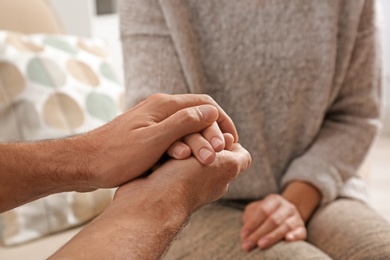 Photo of Man comforting woman, closeup of hands. Help and support concept