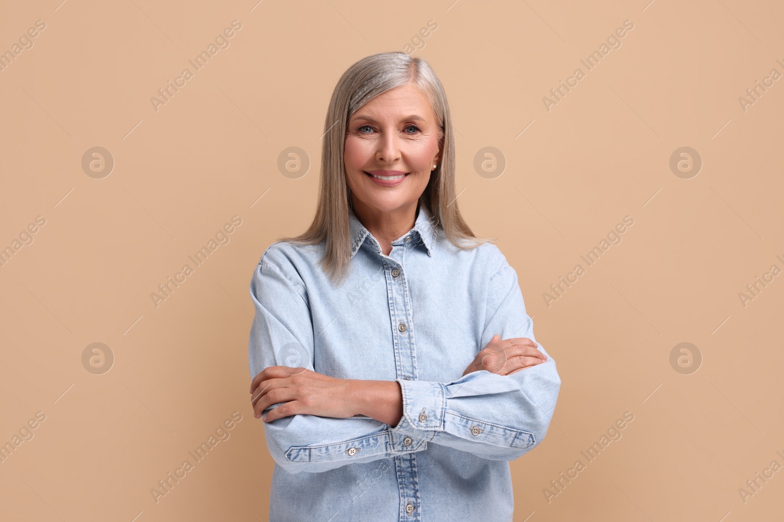 Photo of Portrait of beautiful middle aged woman on beige background