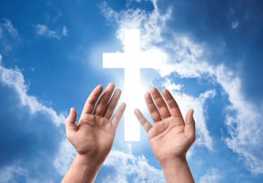 Image of Religion. Christian man praying against sky with glowing cross, closeup