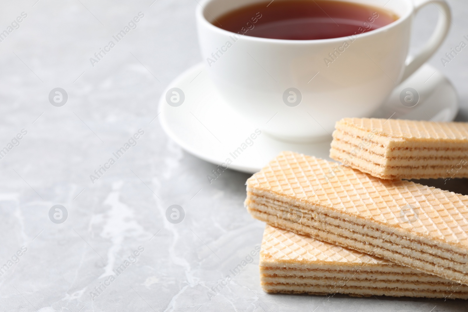 Photo of Delicious cream wafers on light grey marble table, closeup. Space for text