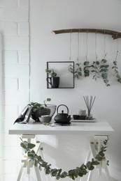 Stylish room decorated with beautiful green eucalyptus branches