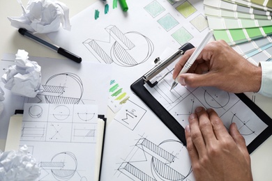 Photo of Male designer working at white table, above view