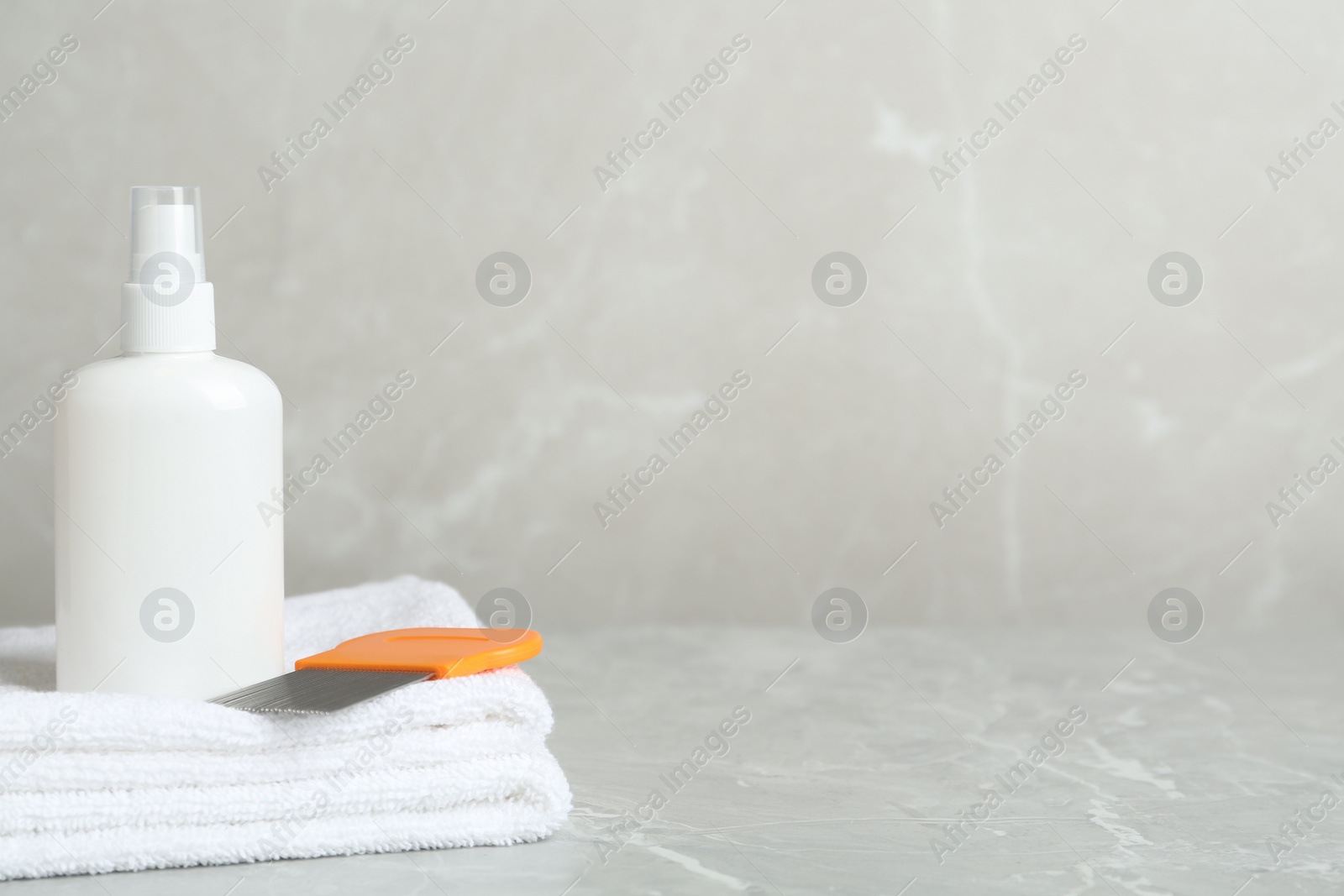 Photo of Cosmetic product, lice comb and towels on light grey table. Space for text